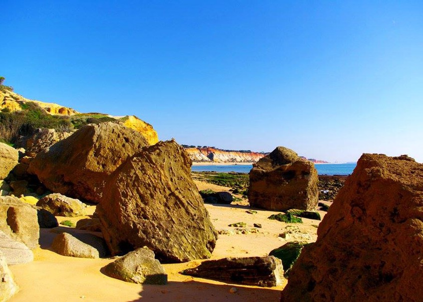 Hinter Olhos de Agua tauchen die imposanten Felsen des Praia da Falesia auf.
